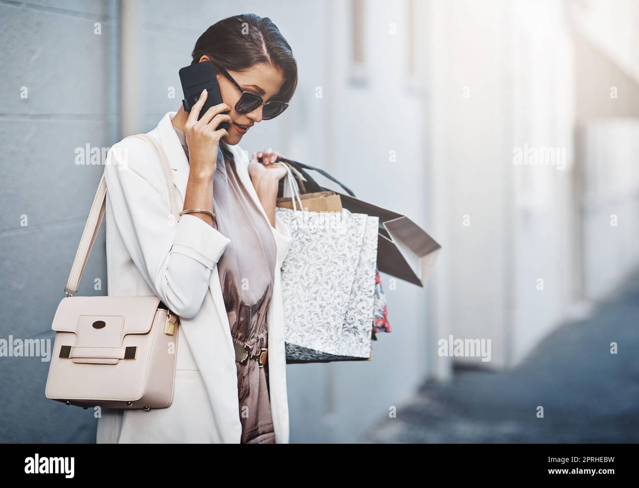 Calling a cab because I bought too many things. a gorgeous and elegant young woman out on a shopping spree. Stock Photo