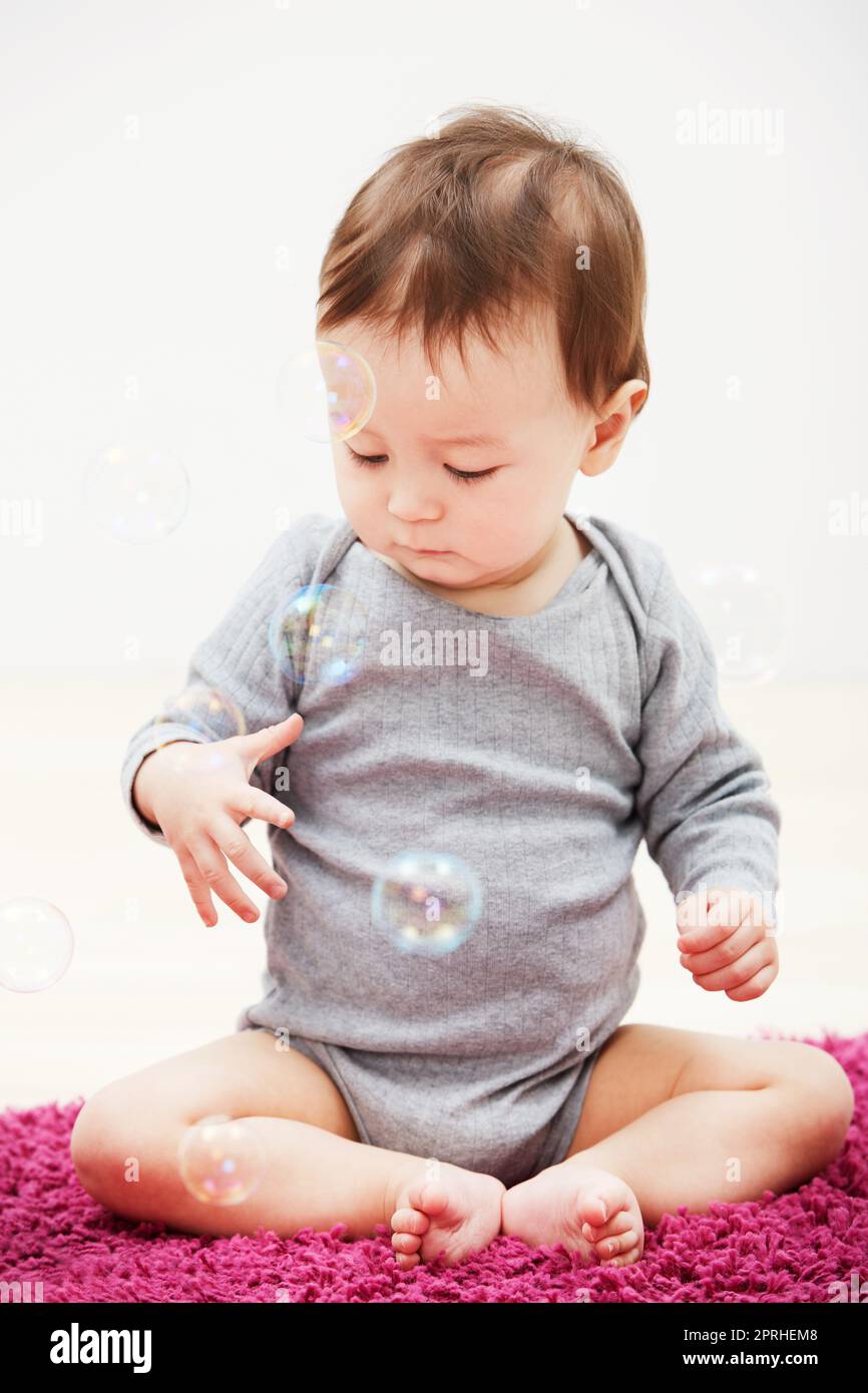 Bubble fun. an adorable baby boy trying to touch bubbles floating in