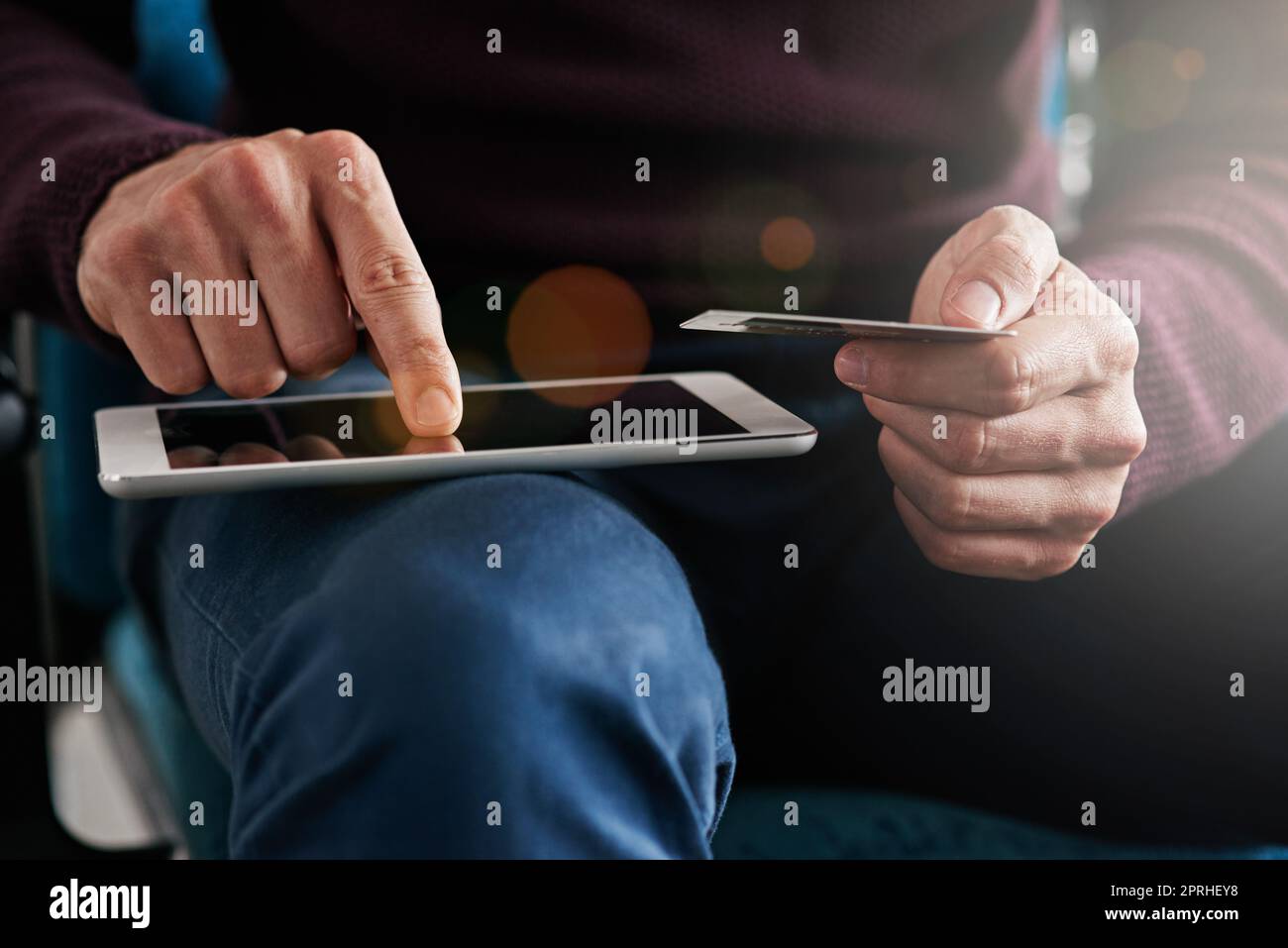Paying for business resources using his credit card. a young man using a digital tablet in an office. Stock Photo