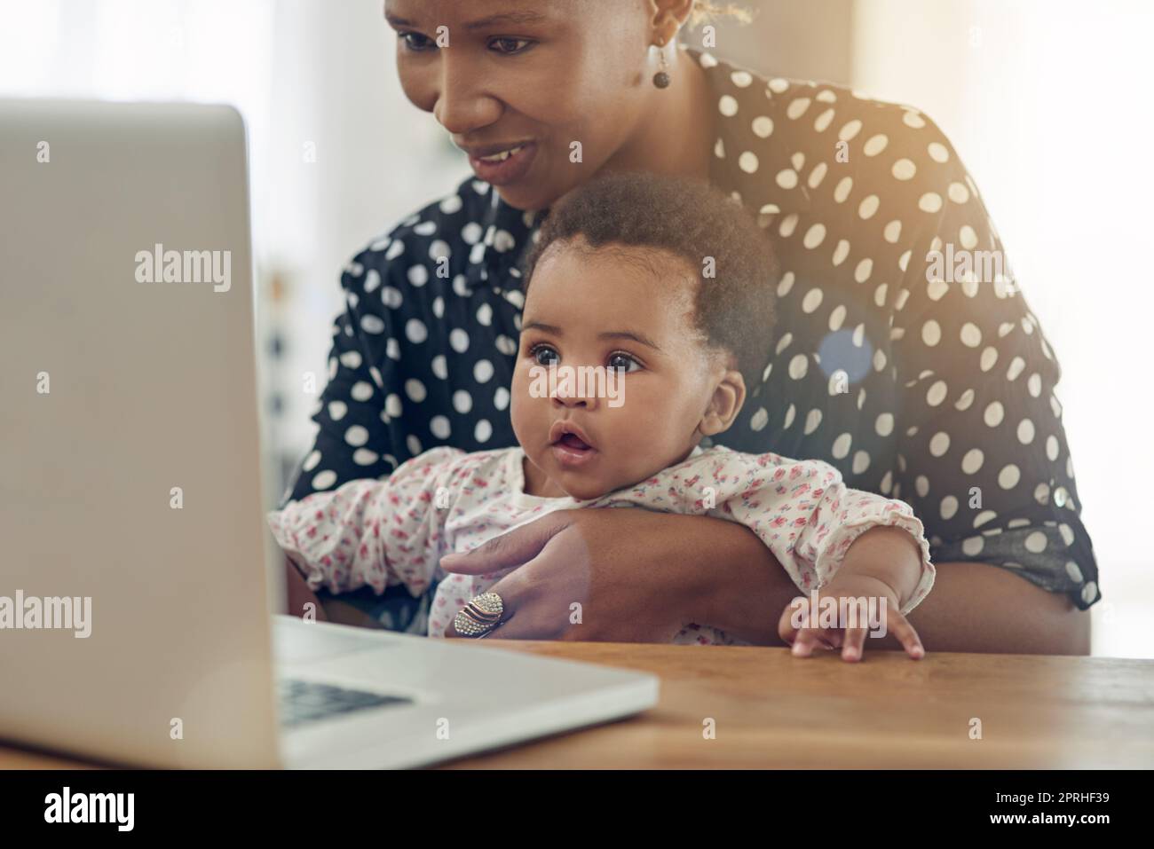 Discovering the world of technology. a mother and her baby girl sitting in front of a laptop. Stock Photo