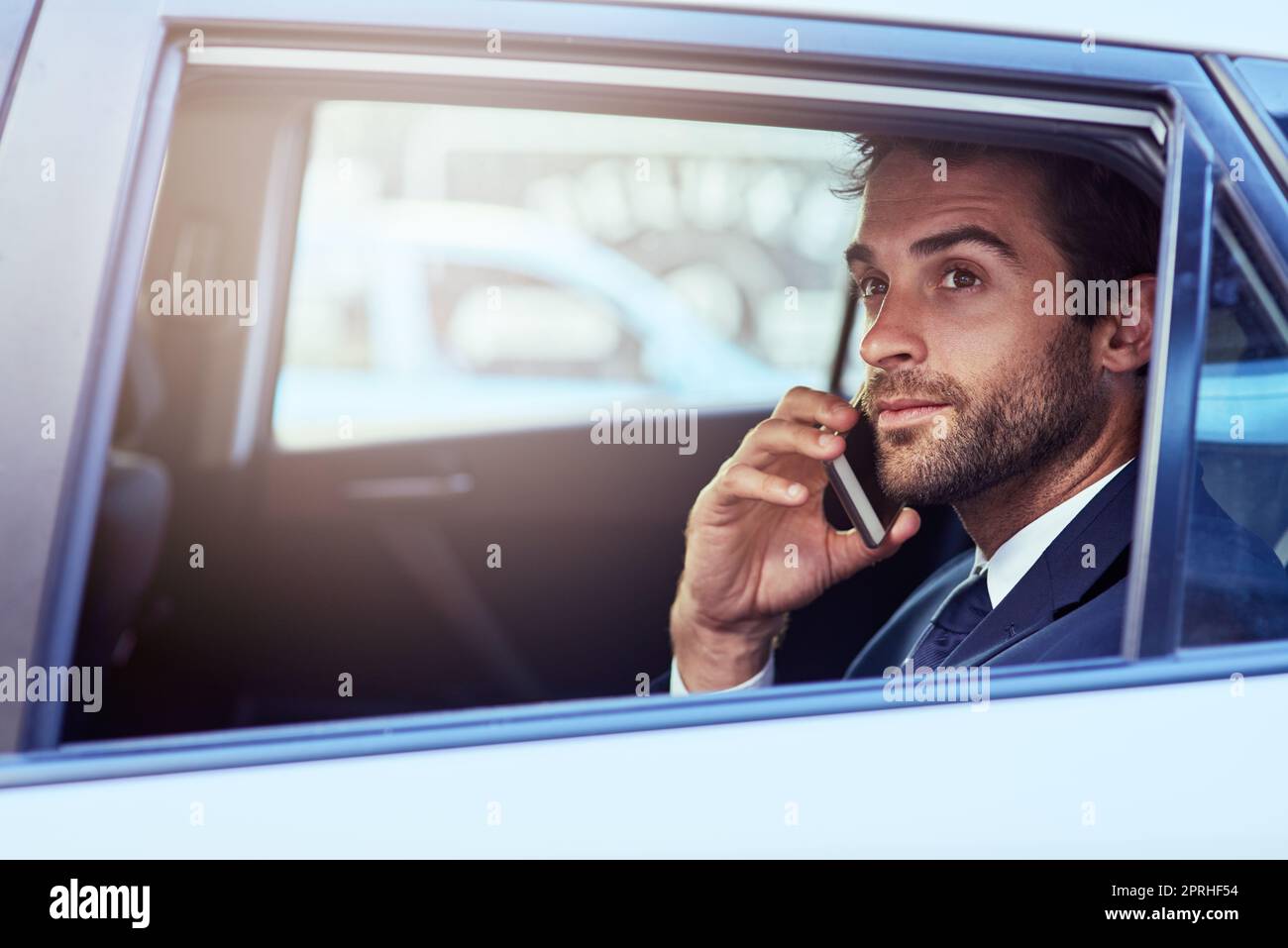 This must me your building, Ill be right up. a businessman talking on the phone while commuting to work. Stock Photo