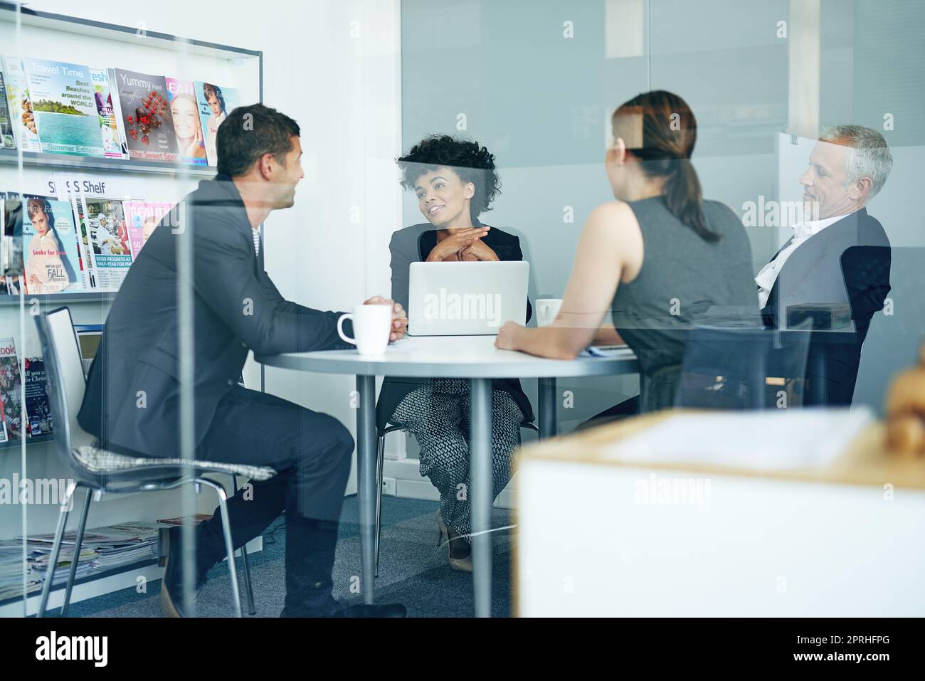 closed door meeting in progress. a group of businesspeople having a meeting together in an office. Stock Photo