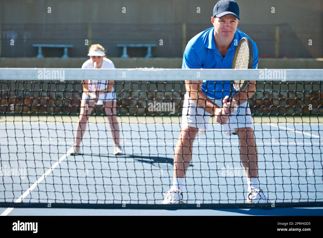 Playing doubles means working together. A mixed doubles team standing