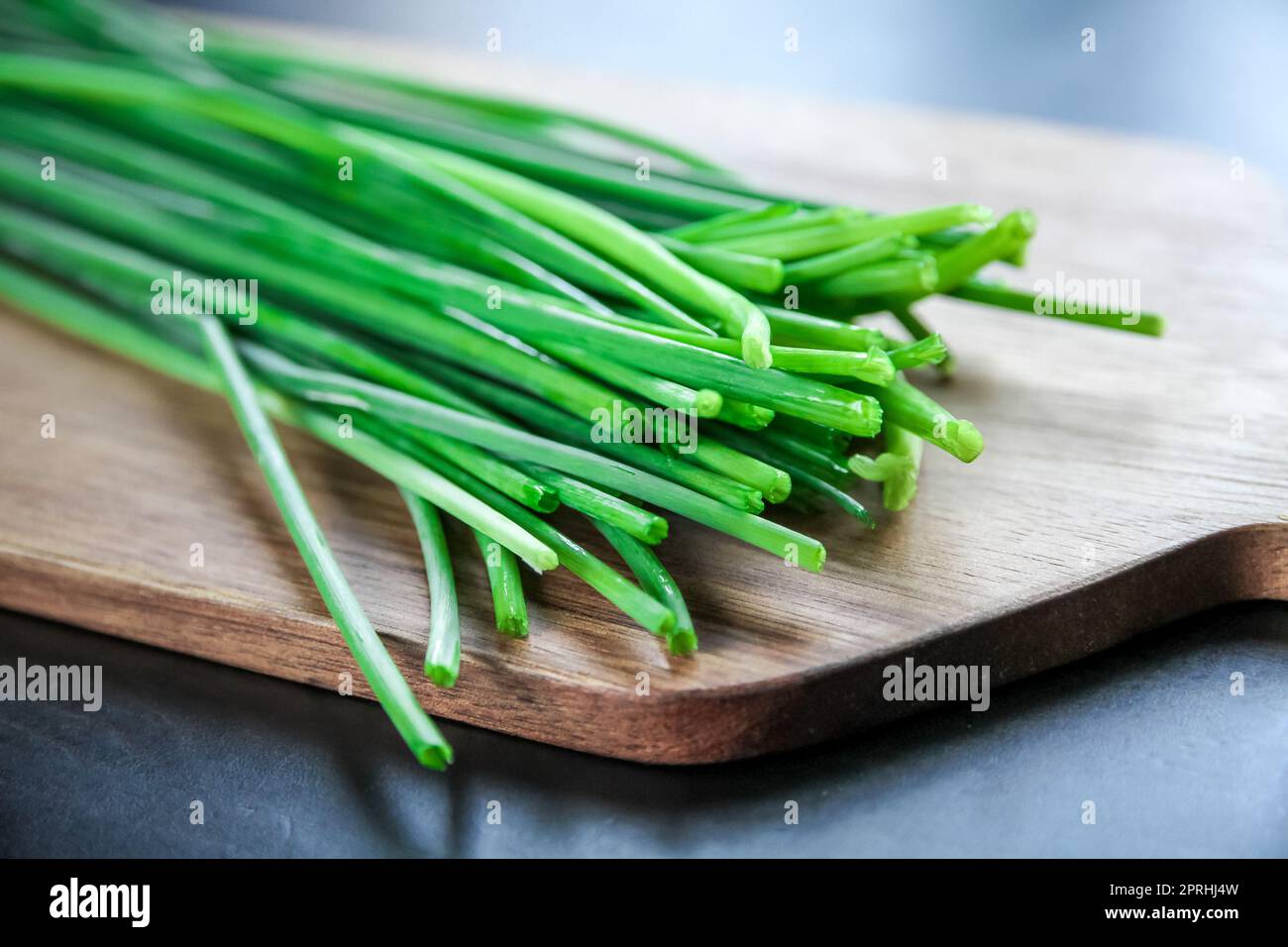 Bunch of chives on a wooden cutting board Stock Photo