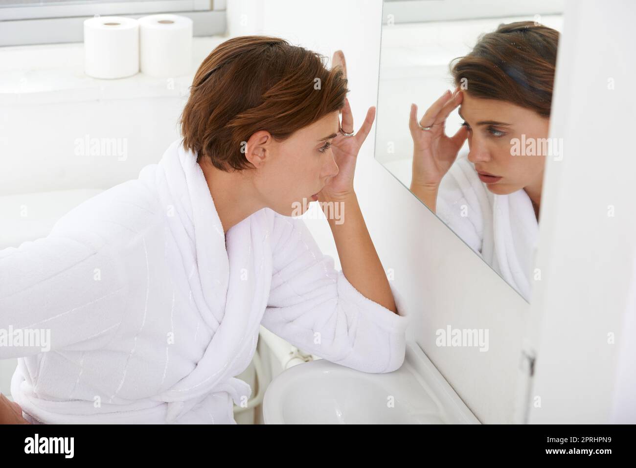 When morning sickness makes its appearance...a pregnant woman experiencing discomfort in the bathroom at home Stock Photo
