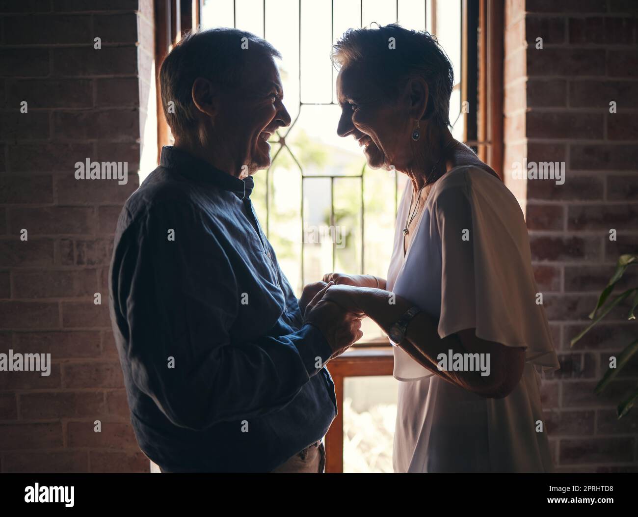 Love, happy family and senior couple laugh and relax in dark room, bond and share funny joke in their home. Retirement, humour and affection by sweet Stock Photo