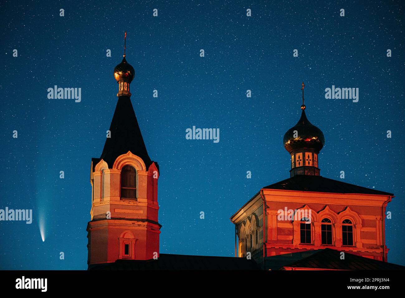 Korma Village, Dobrush District, Belarus. Comet Neowise C2020f3 In Night Starry Sky And St. John The Korma Convent Church In Korma Village. Famous Orthodox Church And Historic Heritage Stock Photo