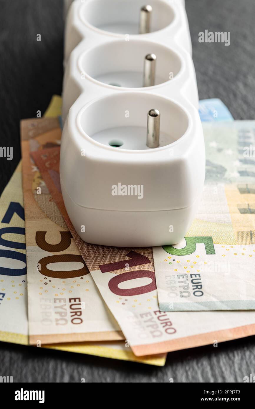 Electric socket and euro money. Concept of increasing electric prices. Stock Photo