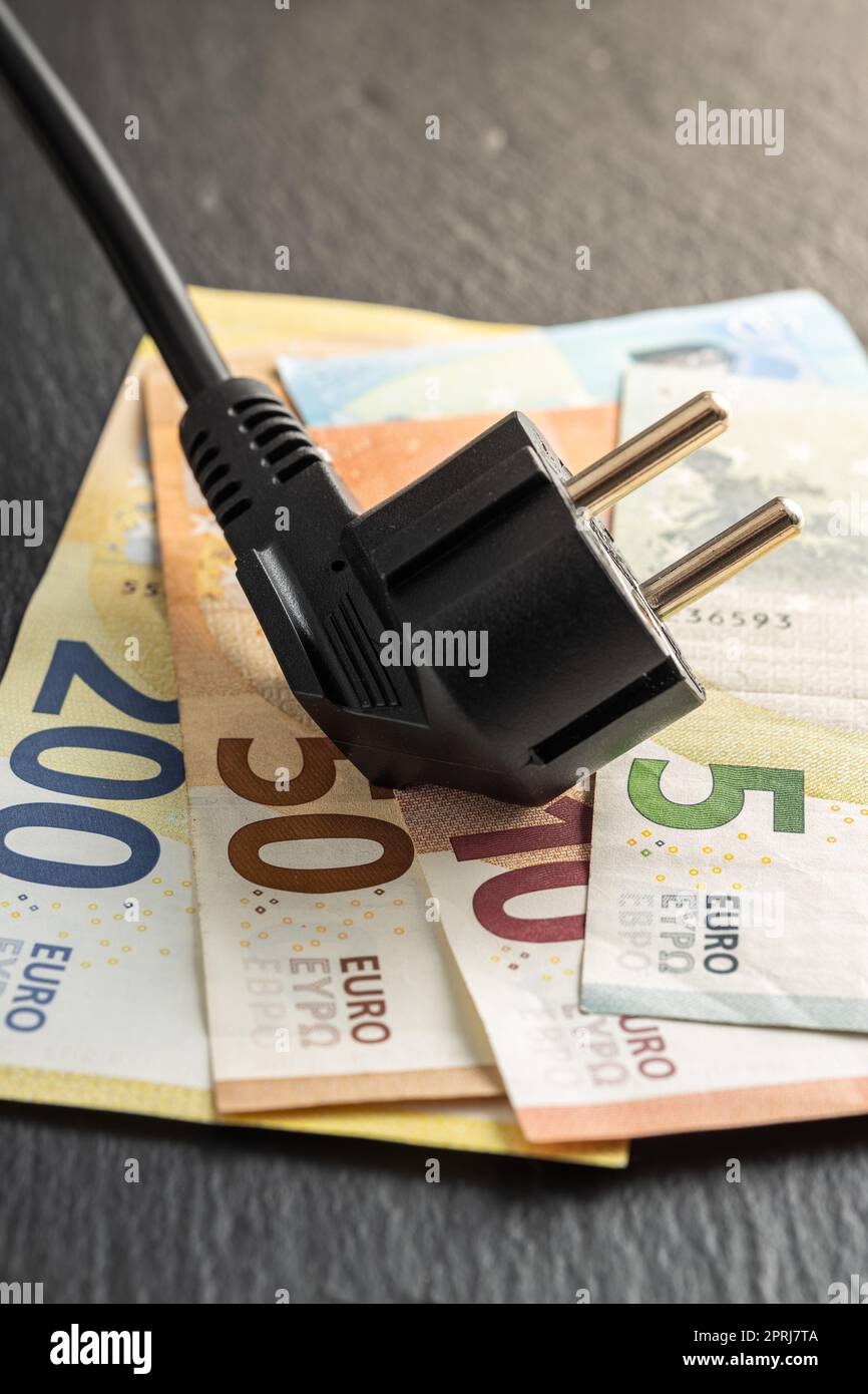 Electric plug and euro money. Concept of increasing electric prices. Stock Photo