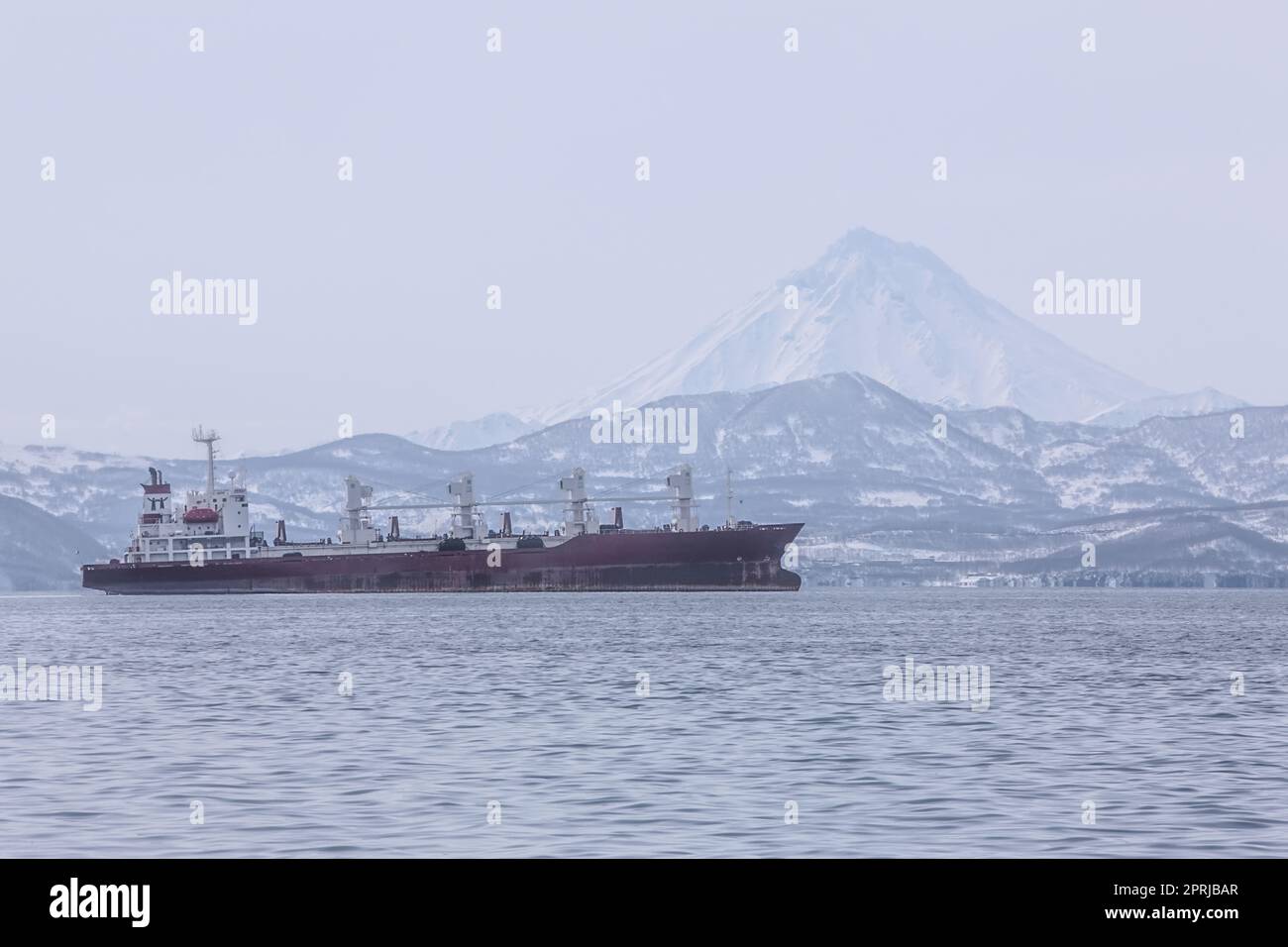 Kamchatka Peninsula, Russia.Seaport in Petropavlovsk-Kamchatsky.Ships in the roadstead against the background of the volcano Stock Photo