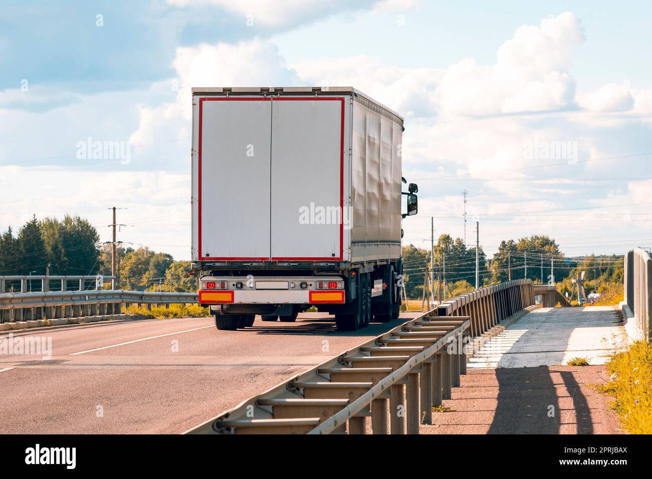 White truck on asphalt road ground with metal safety barrier Stock Photo
