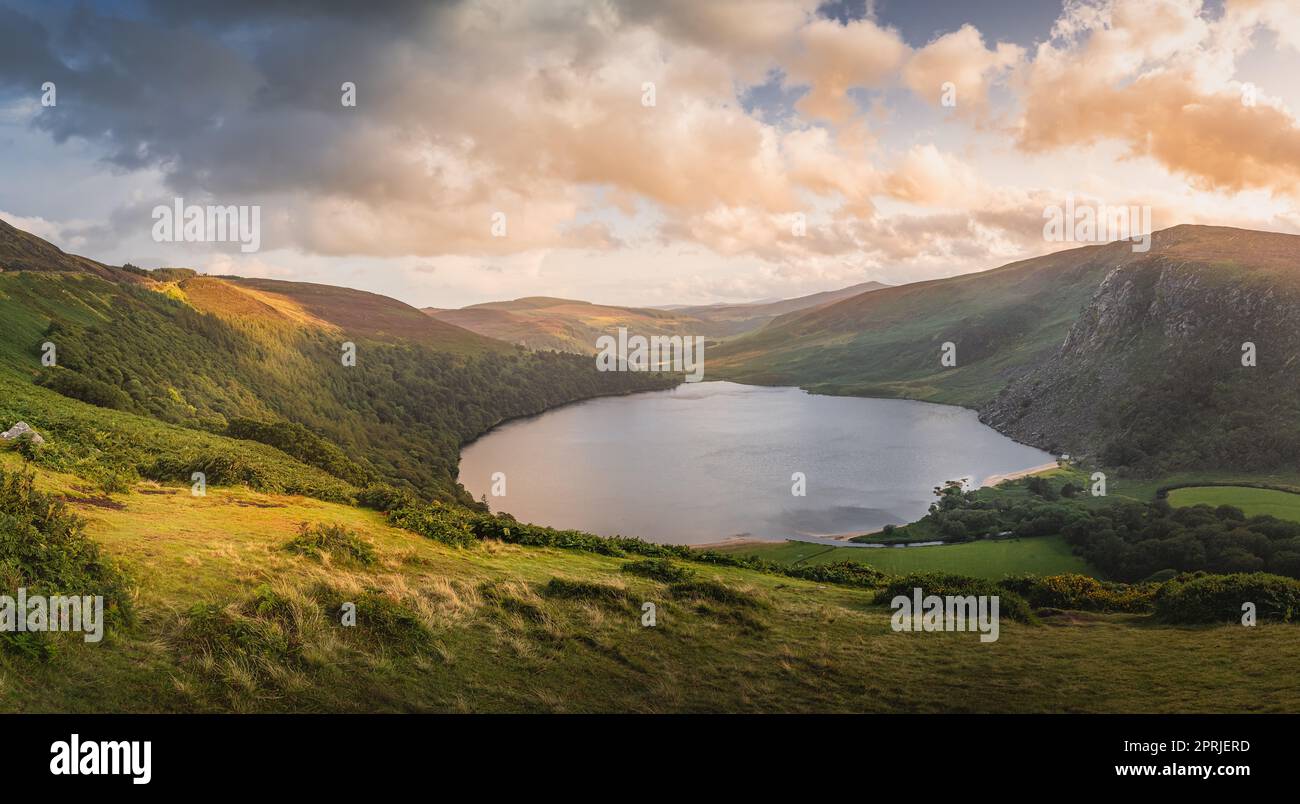 Beautiful panorama with dramatic sunset at Lough Tay, called The Guinness  Lake located in deep valley and surrounded by Wicklow Mountains, Ireland  Stock Photo - Alamy
