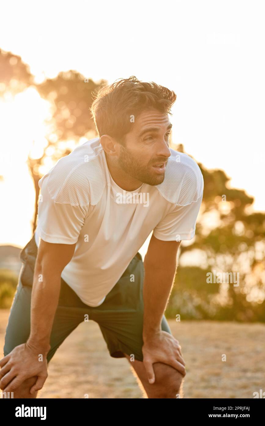 Catching his breath. a man taking a breather while out for a run. Stock Photo