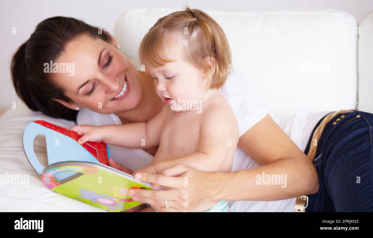 Looking at the colours. A cute little girl paging through a book with