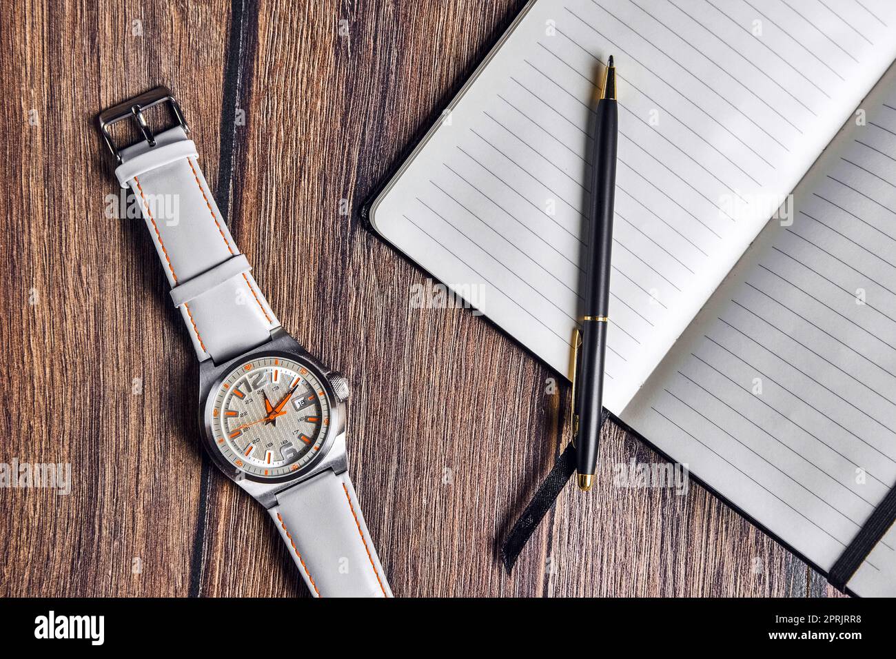Top view of open blank notebook with pen and wrist watch on wooden ...