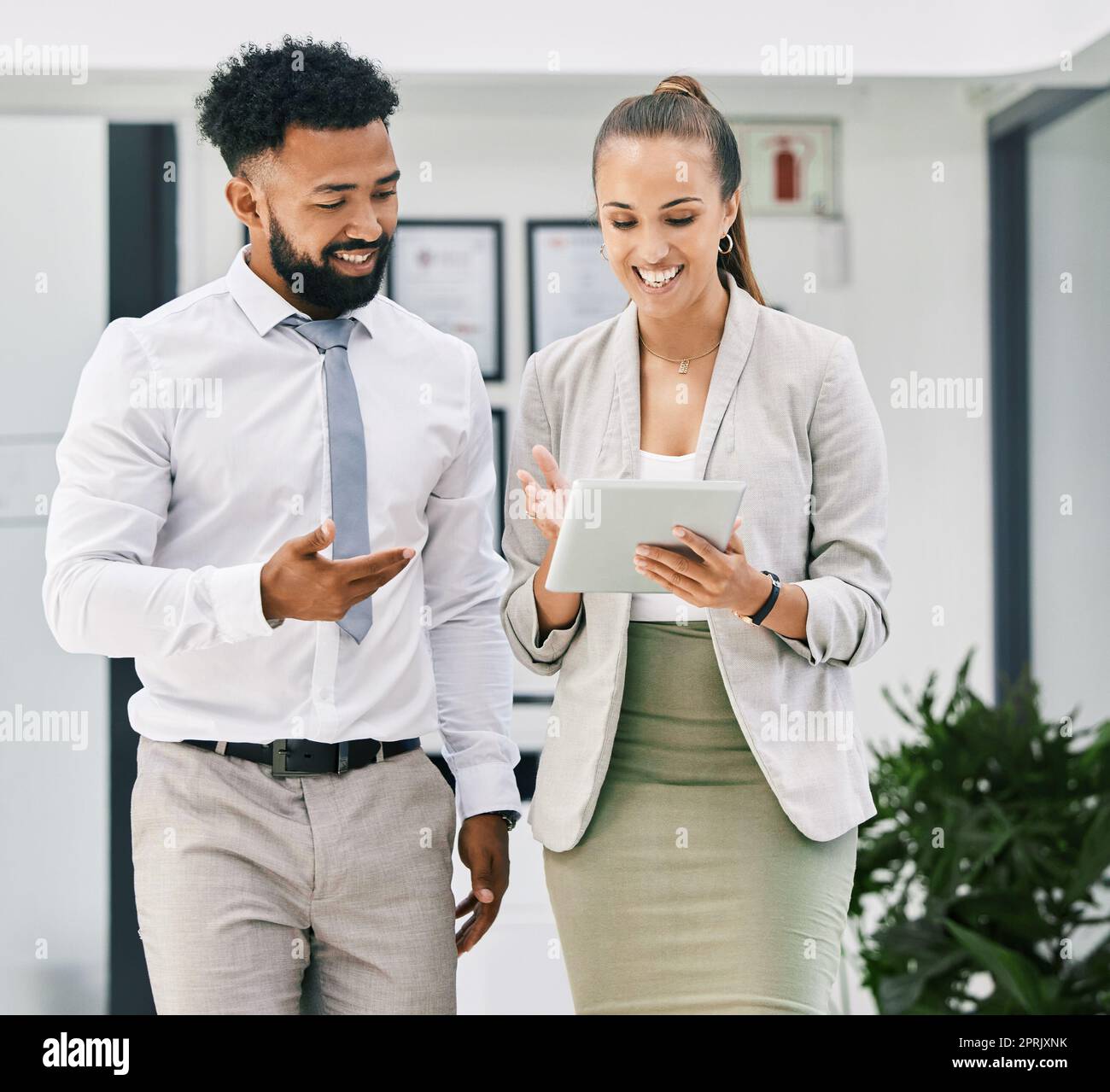 Business people, collaboration and teamwork with tablet in office for walking man and woman planning corporate strategy. Happy employees with smile, motivation or success vision on digital technology Stock Photo