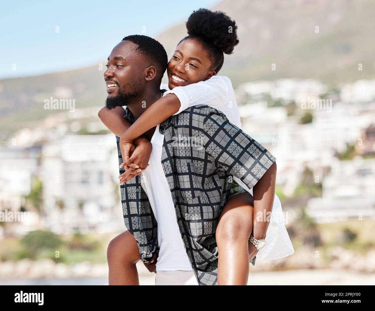 Love, couple and beach with a playful man and woman enjoying a holiday or vacation on the coast together. Travel, summer and romance with a boyfriend and girlfriend bonding outside during a sunny day Stock Photo