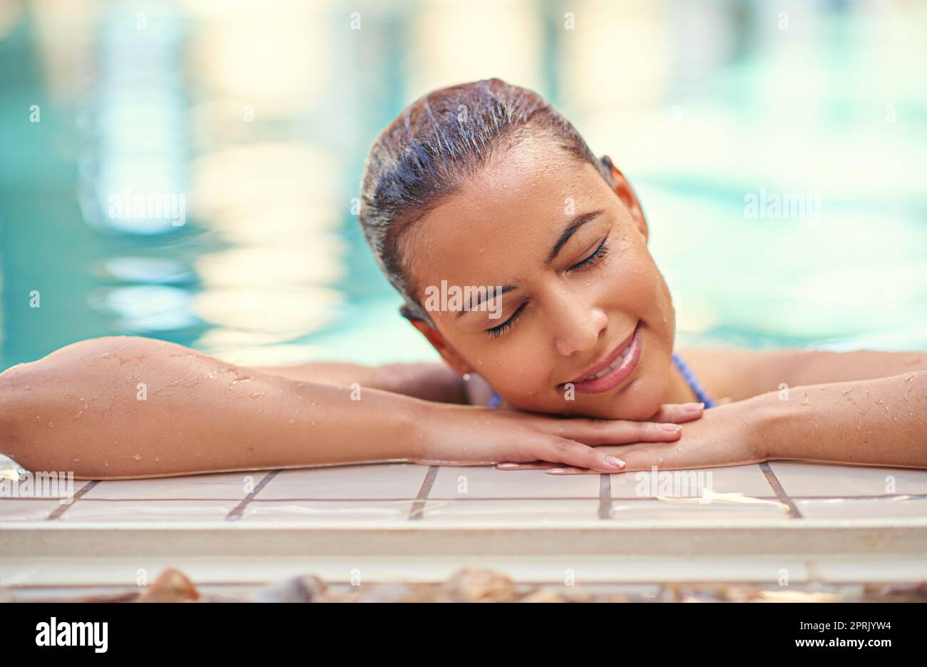 Swim your worries away. a young woman relaxing in the pool at a spa. Stock Photo