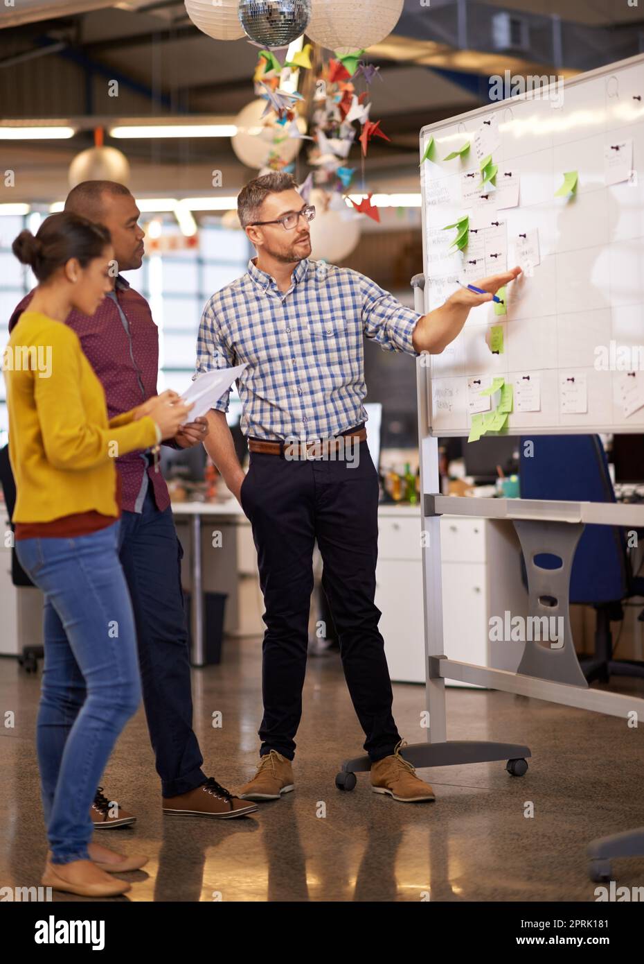 Together we can constantly come up with new ideas. a group of coworkers brainstorming at a whiteboard. Stock Photo