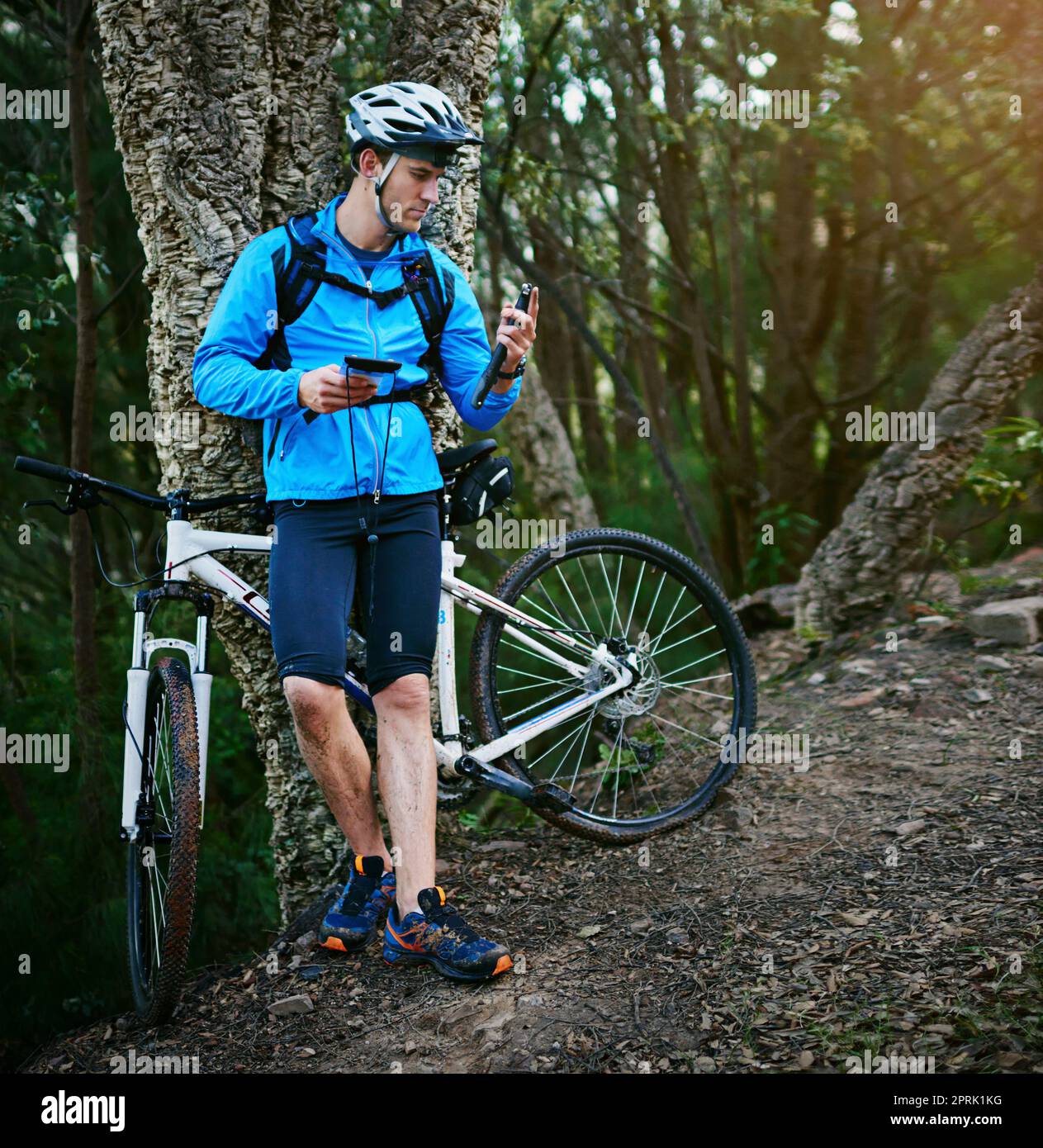 Be prepared for anything. a male cyclist standing by his mountain bike holding a bicycle pump. Stock Photo