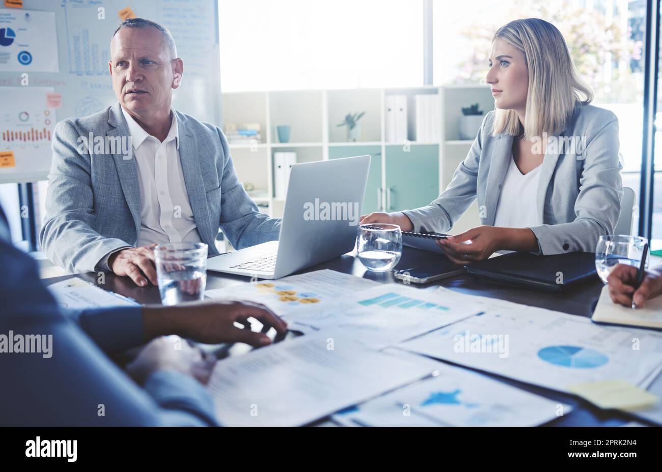Serious people in business meeting discussion, planning strategy for company financial report with charts, graph and data. Team manager man and woman listening to review of corporate marketing growth Stock Photo