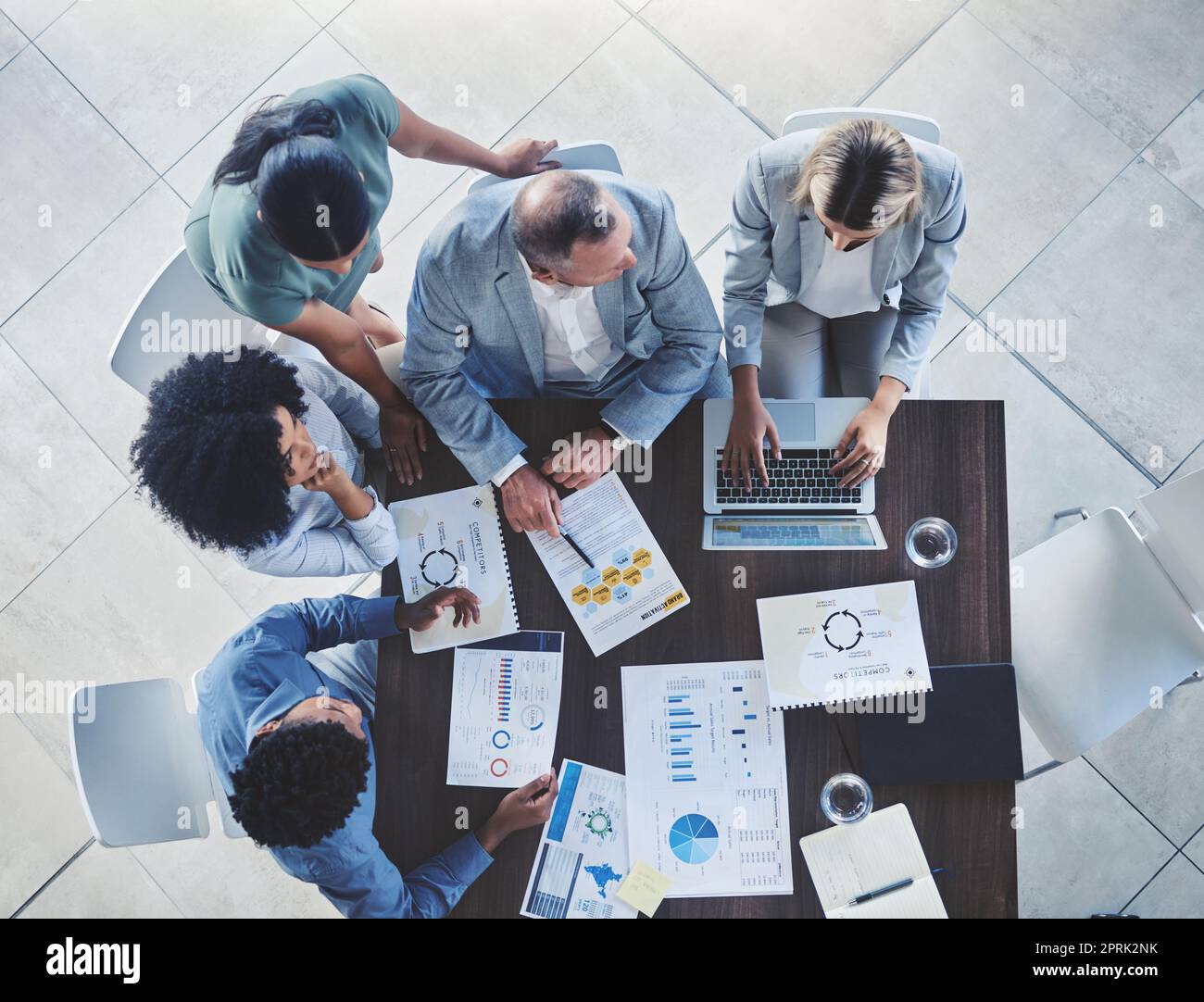 Conference team, table and discussion about documents at corporate meeting for data development. Analysis, cooperation and administration conversation with business office people overhead. Stock Photo