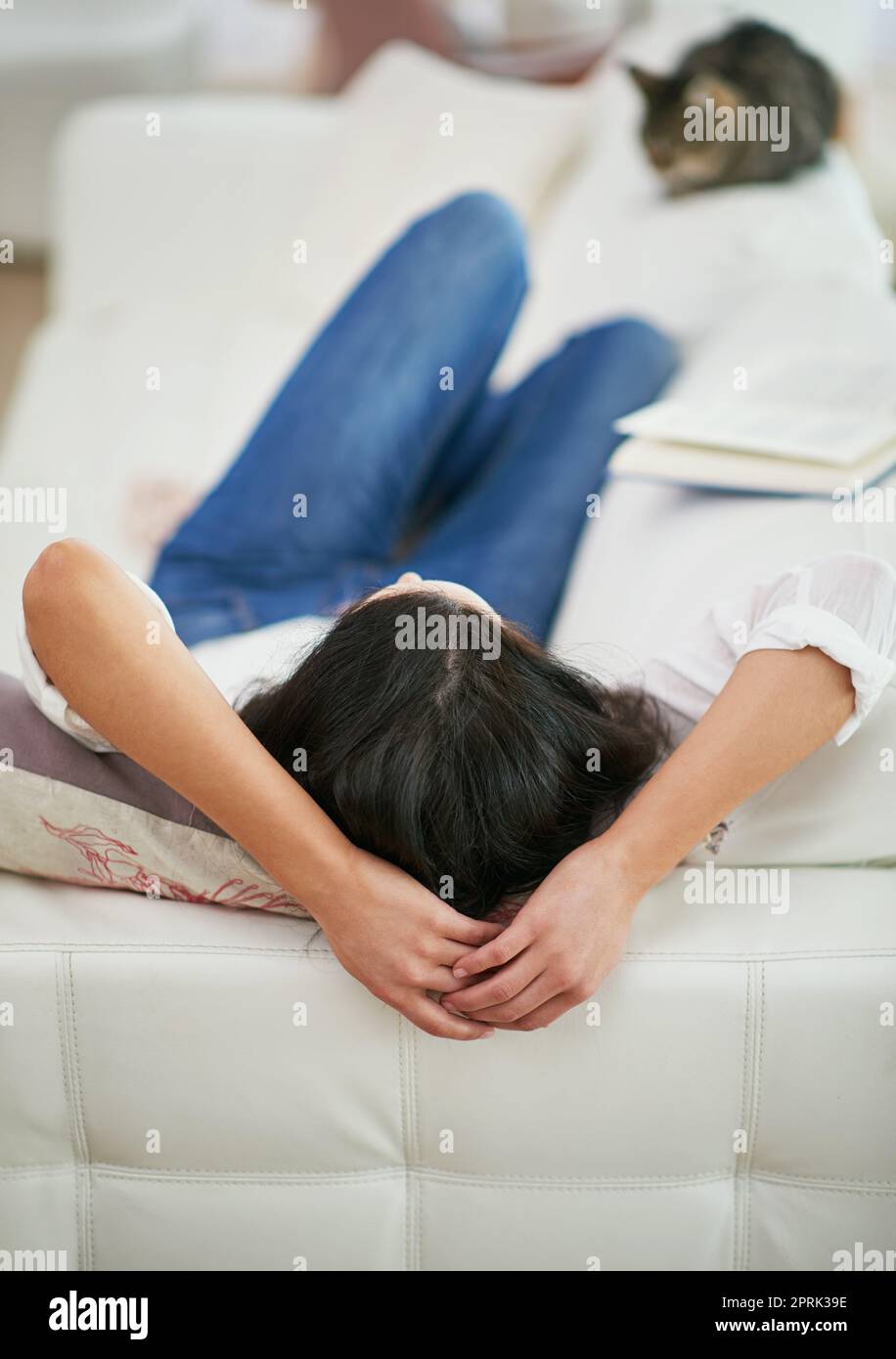 Relax and unwind. Rearview shot of a young woman lying on her couch. Stock Photo
