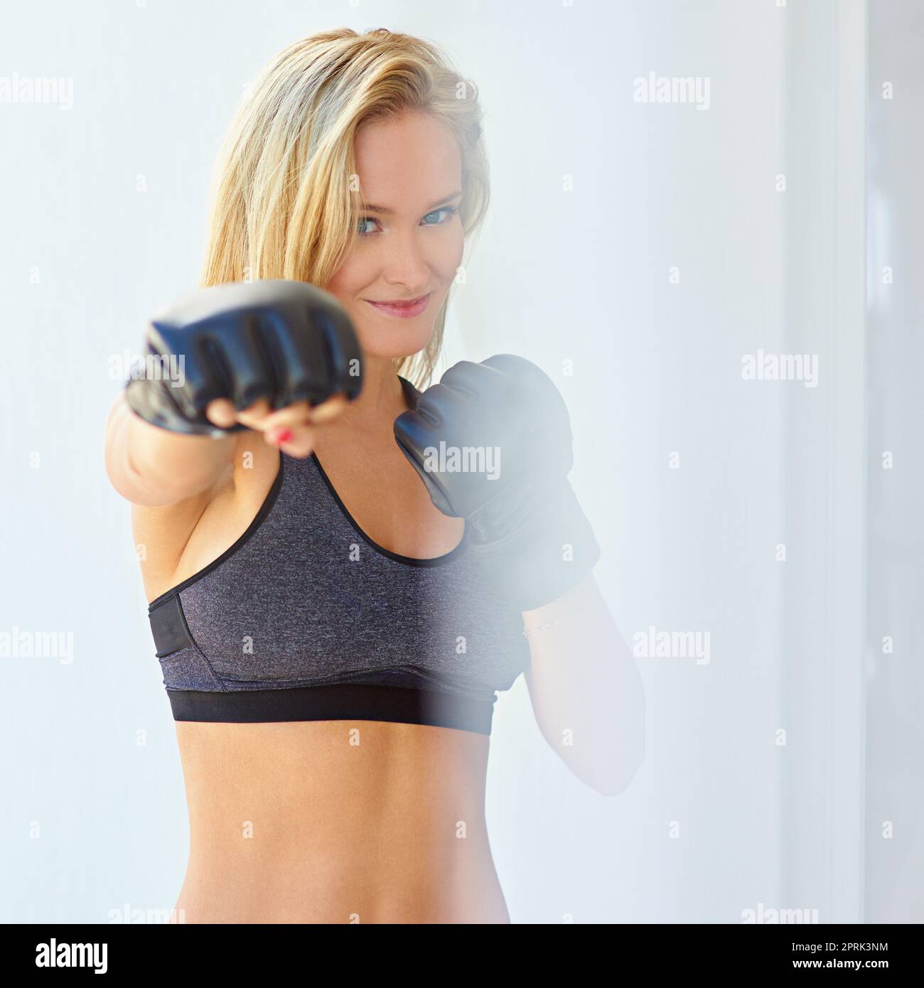 When life gets tough, put on your boxing gloves. a sporty young woman training with mma gloves