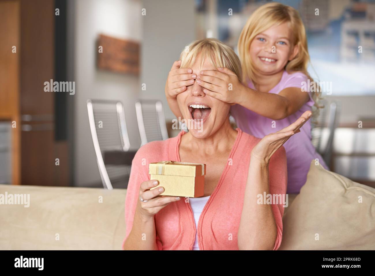 Open your hands and close your eyes for a big surprise. a young girl surprising her mother with a gift Stock Photo