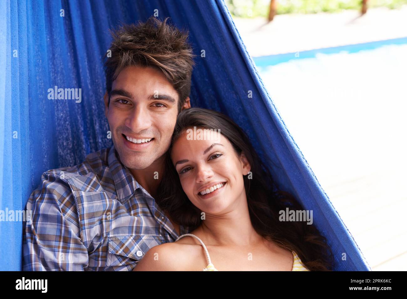 Happy holiday together. Portrait of an affectionate young couple lying in a hammock Stock Photo