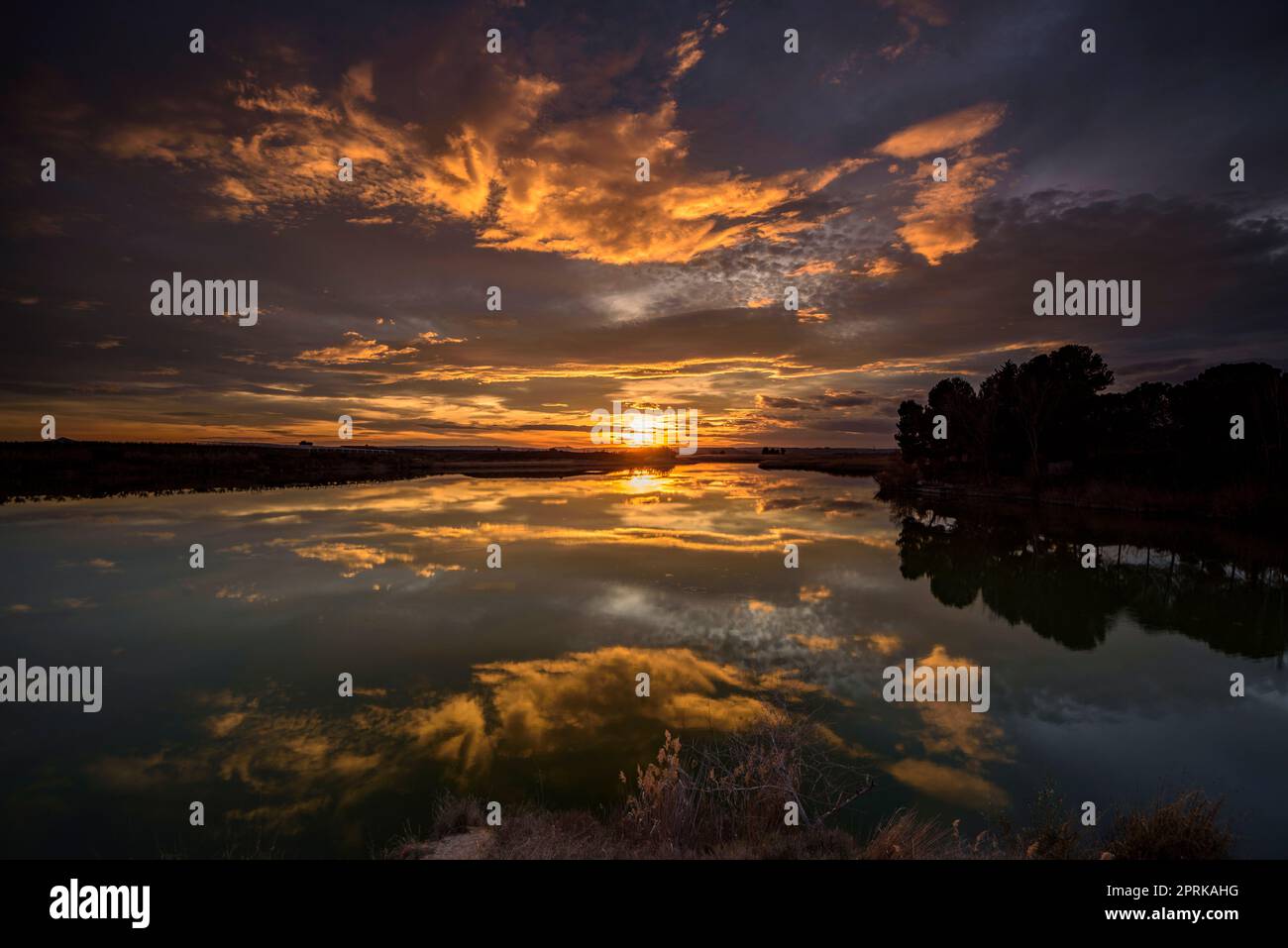 Sunset with a red sky in the Utxesa reservoir in Torres de Segre (Segrià, Lleida, Catalonia, Spain) ESP: Atardecer con cielo rojizo en Utxesa Stock Photo