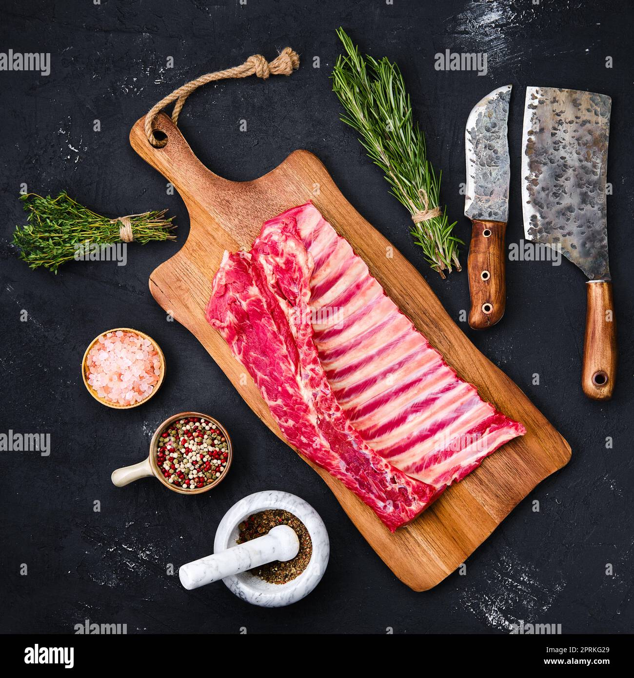 https://c8.alamy.com/comp/2PRKG29/fresh-raw-rack-of-lamb-on-wooden-cutting-board-with-herbs-and-seasoning-2PRKG29.jpg