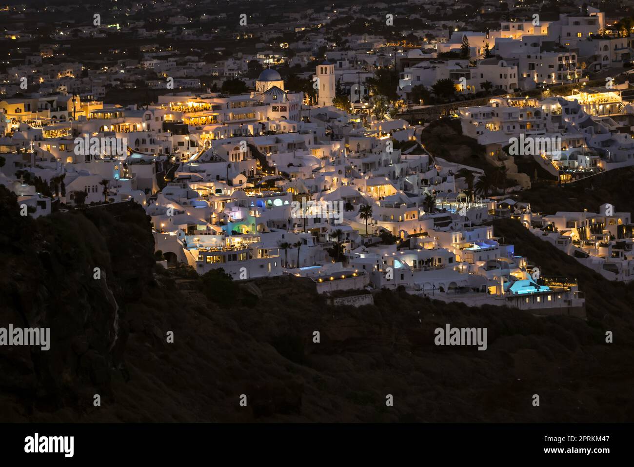 Illuminated whitewashed houses with terraces and pools and a beautiful view in Oia on Santorini island, Greece Stock Photo