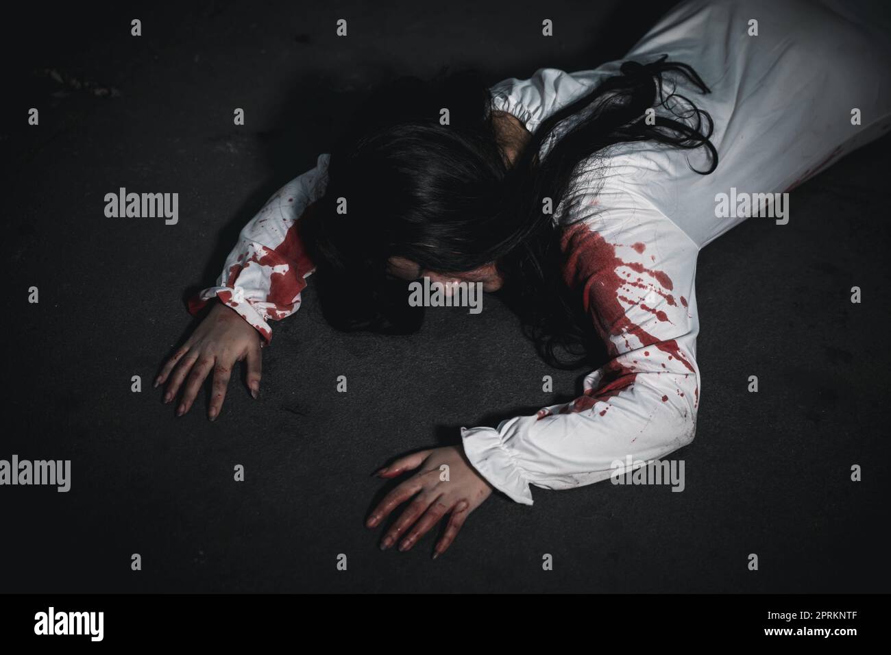 Horror bloodthirsty woman ghost horror she death and scary at dark night in tunnel, The girl was hit by a car and lying died on the road. full of bloo Stock Photo