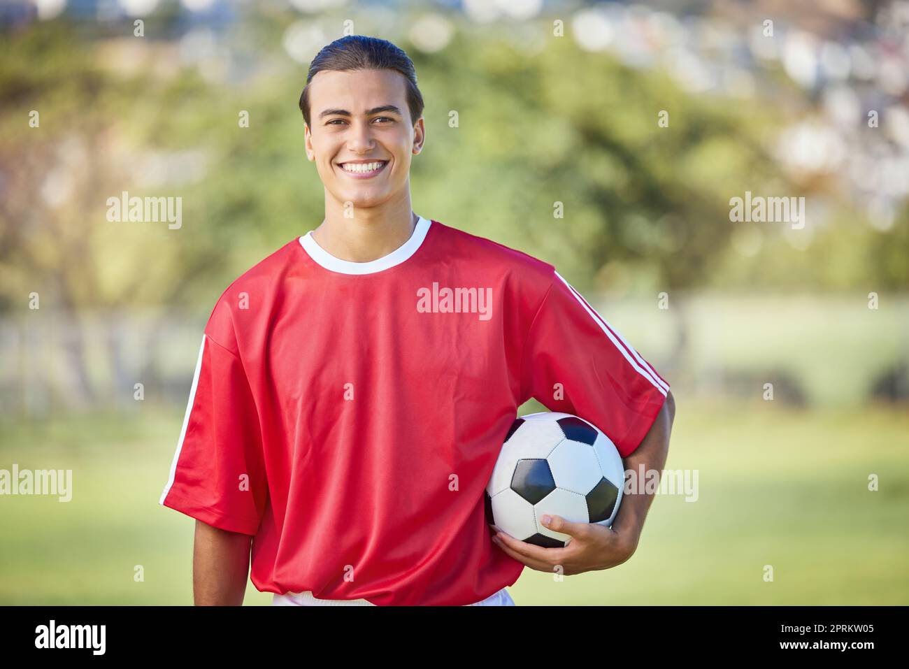 Soccer, sports and fitness with a man athlete holding a ball on a field