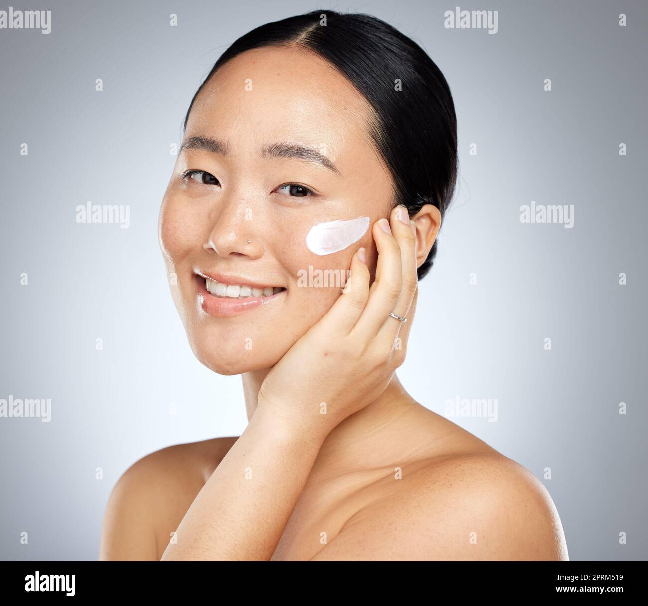 Woman, face cream or grooming skincare routine on studio background for