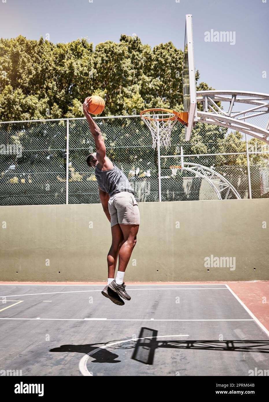 Basketball dunk, sport and strong black man athlete on a outdoor