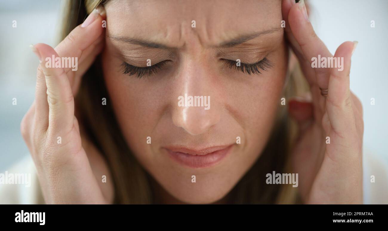 This headache wont go away. an attractive woman looking stressed Stock