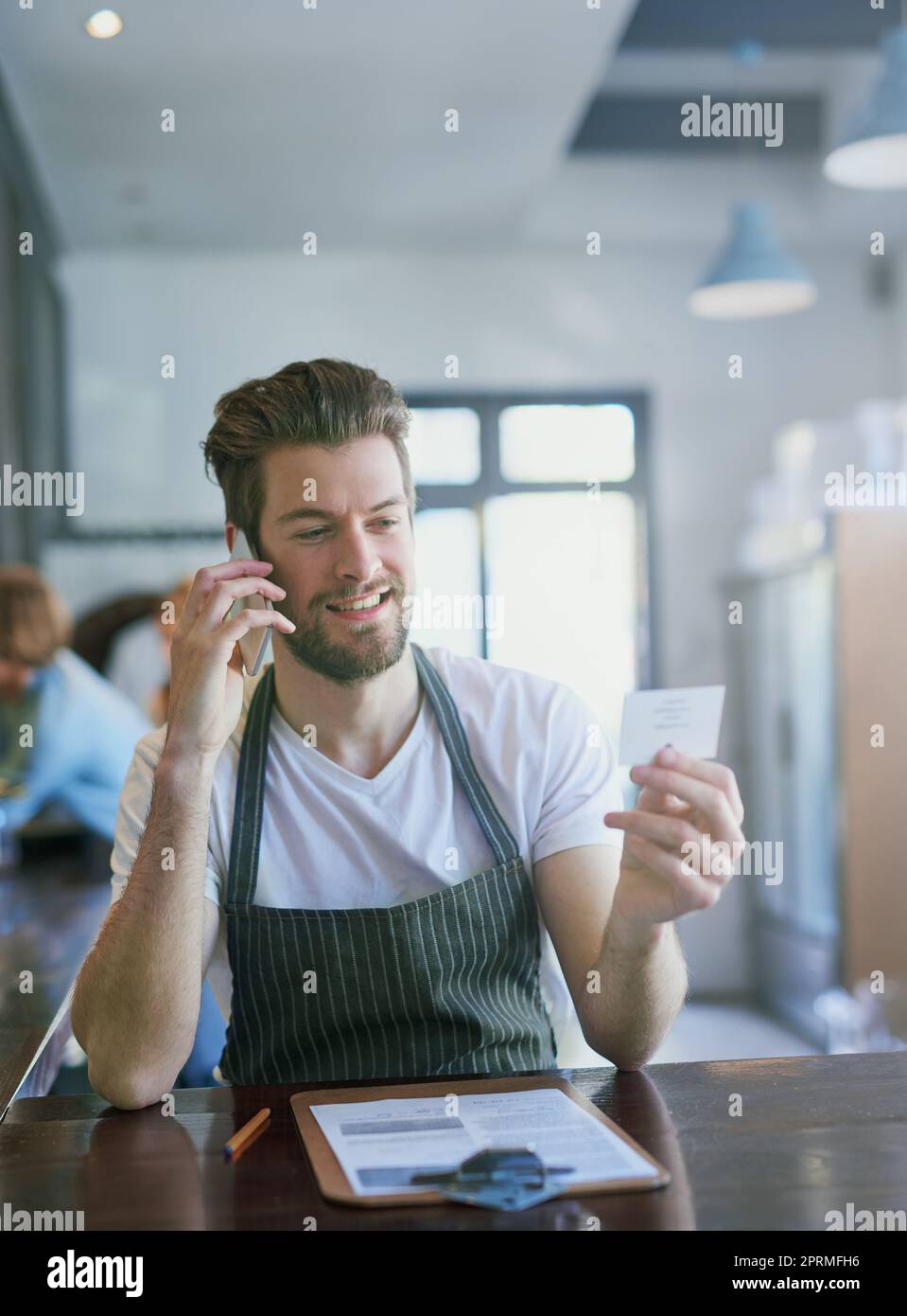 https://c8.alamy.com/comp/2PRMFH6/making-sure-hes-got-the-correct-delivery-address-a-young-barista-taking-orders-via-cellphone-2PRMFH6.jpg