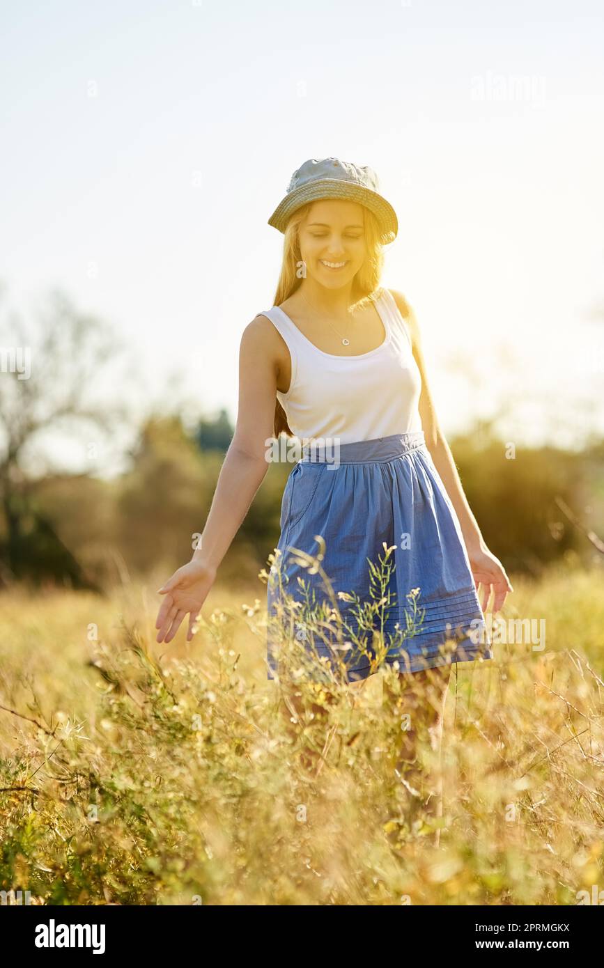 Nature has a soothing affect on the mind and body. a young woman on a tree stump out in the countryside. Stock Photo
