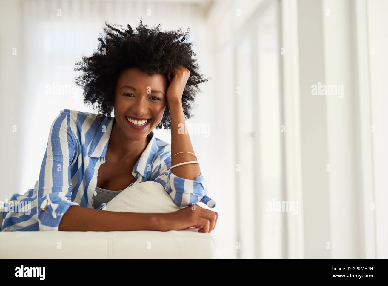 My weekends are all about taking it easy. Portrait of a young woman relaxing at home. Stock Photo