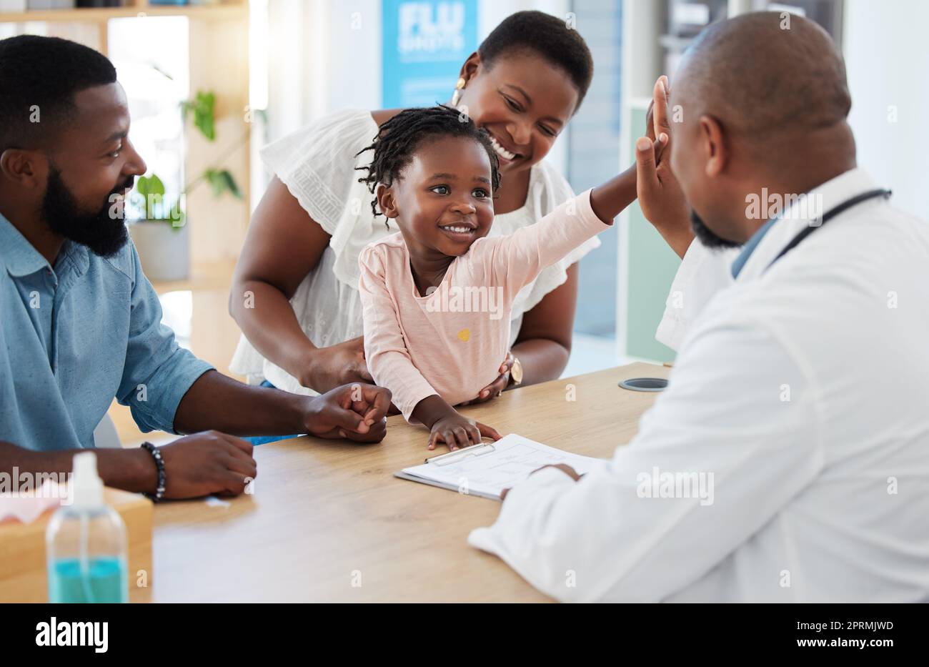 High five, doctor and family with a girl and her parents at the hospital for consulting, appointment and healthcare. Medicine, trust and support in a medical clinic with a health professional Stock Photo