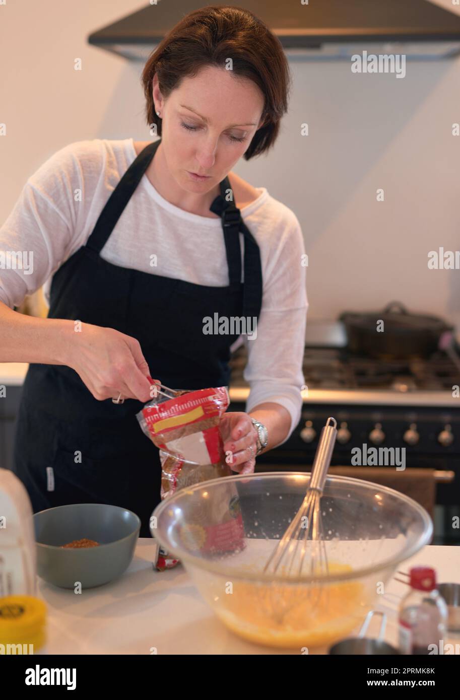 Flour in white bowl measuring on digital scale with baking ingredients and  utensil on marble kitchen table Stock Photo