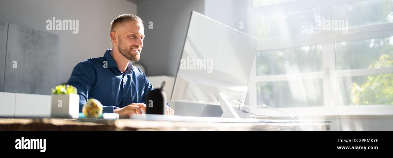 Employee Working On Desktop Computer Stock Photo