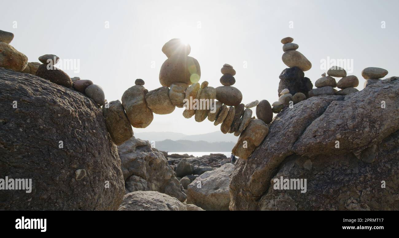 Arch of pebbles in balancing on the sea coast Stock Photo