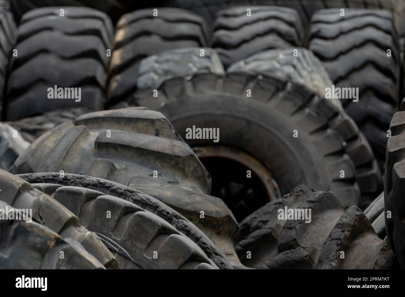 Closeup used truck tires. Old tyres waste for recycle or for landfill. Black rubber tire of truck. Pile of used tires at recycling yard. Material for landfill. Recycled tires. disposal waste tires. Stock Photo