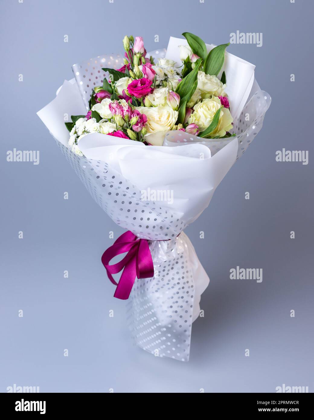 Bouquet of roses, eustoma and irises on a blue background. Stock Photo