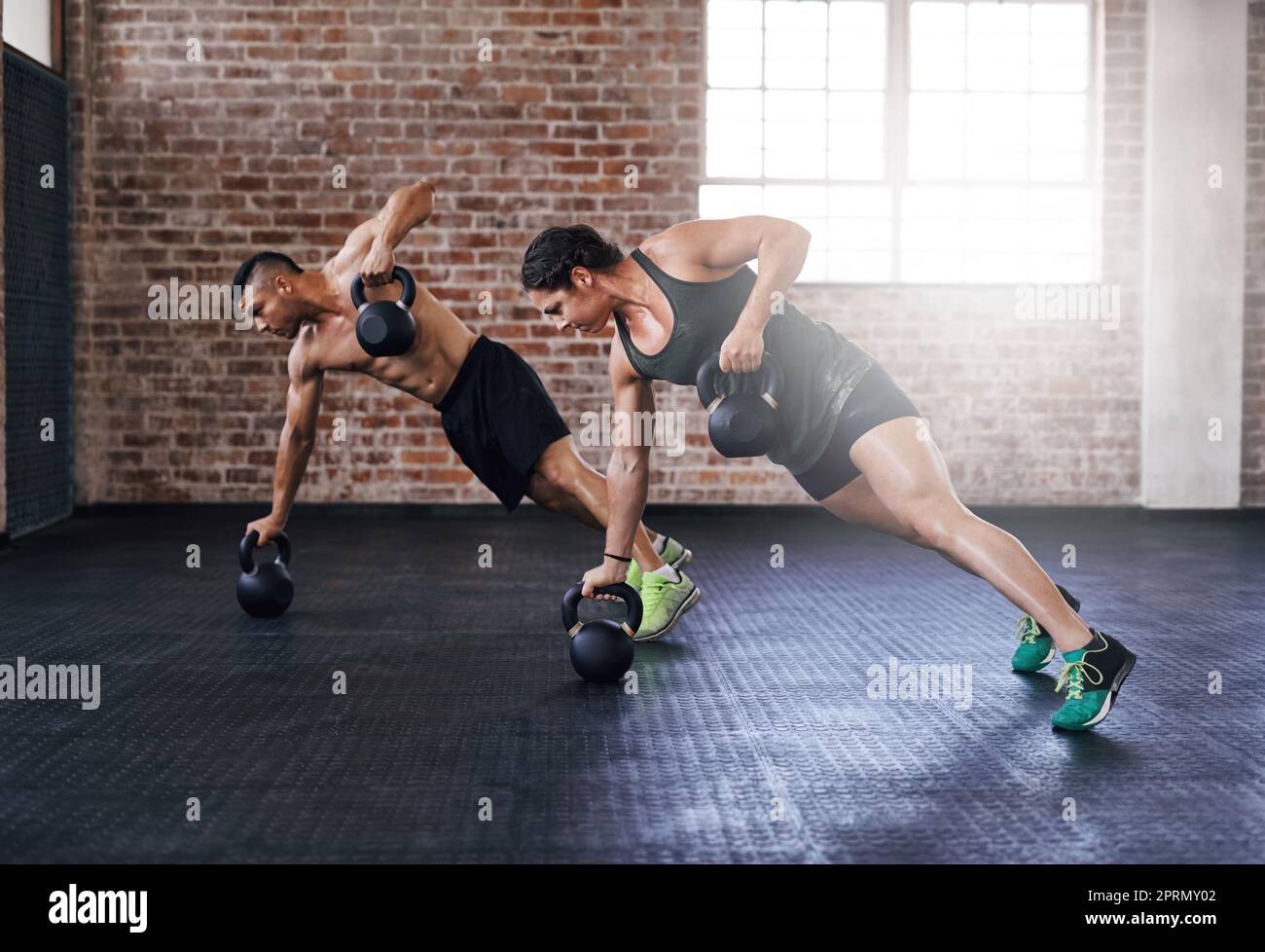 Its a display of absolute power. Full length shot of two young athletes working out in the gym. Stock Photo