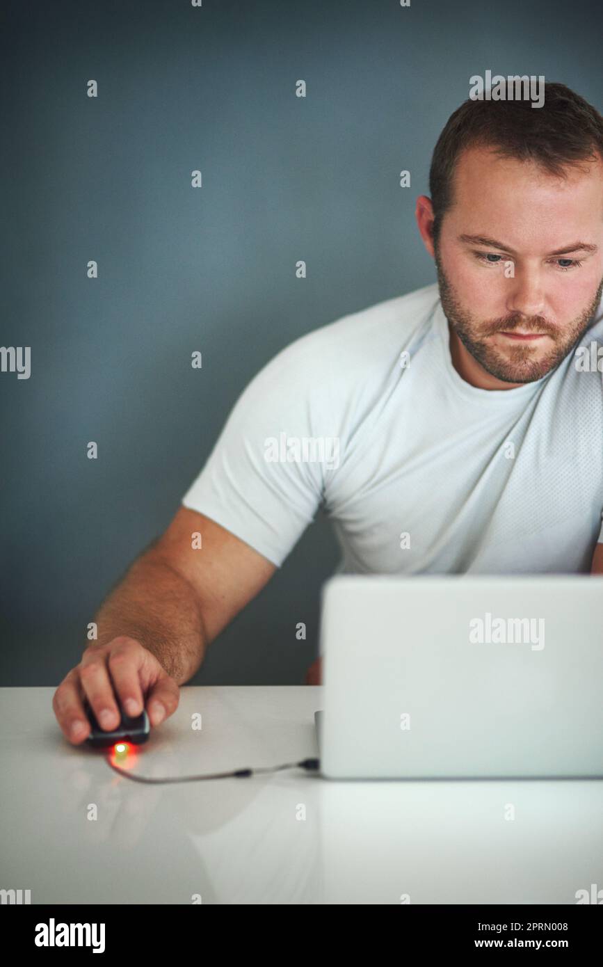 Hes taken up blogging. a young man working on his laptop. Stock Photo