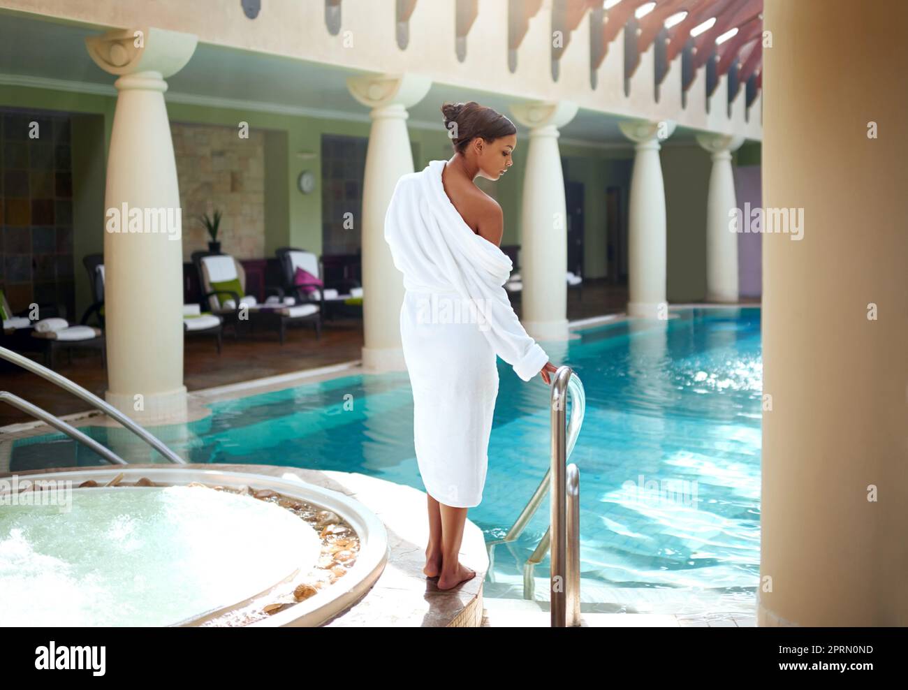 Water is just what I need to relax. an attractive young woman about to go for a relaxing swim at a spa. Stock Photo